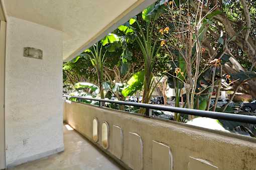 A balcony with a railing and a wall with a small plaque on it.