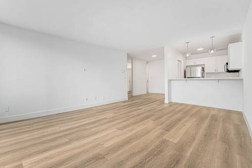 A room with wooden flooring and white walls.