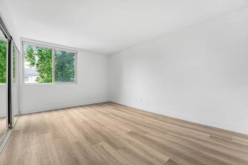 A room with a window and wooden flooring.