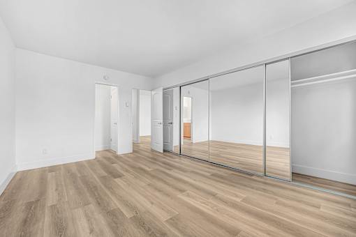 A room with a white wall and a wooden floor.