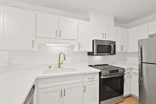 A kitchen with white cabinets and a black stove top oven.