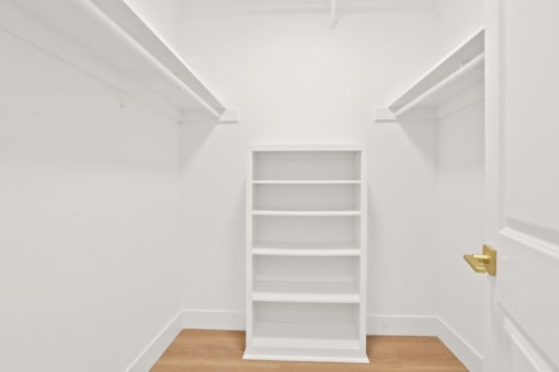 A white shelving unit in a white room.