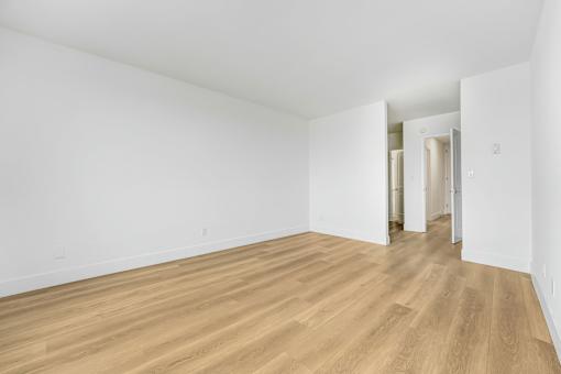 A room with wooden flooring and white walls.