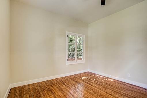 A room with a window and wooden flooring.