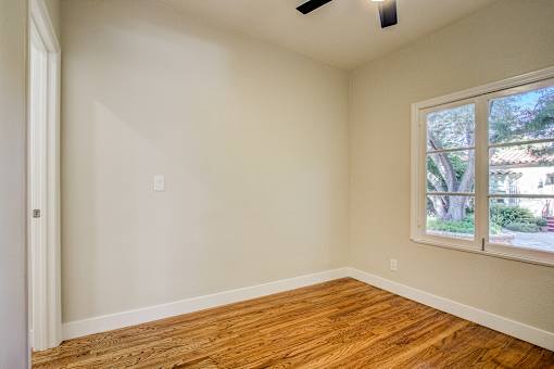 A room with a window and wooden floors.