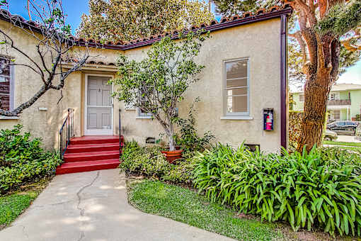 A house with a red door and a red staircase leading to it.