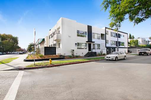 A white building with black accents sits on a street corner.