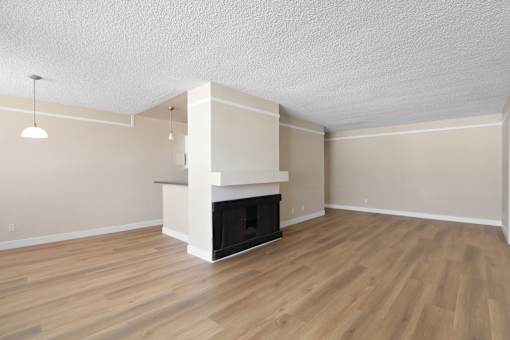 A room with a fireplace and wooden floors.