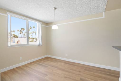 Empty room with a window overlooking a beach.