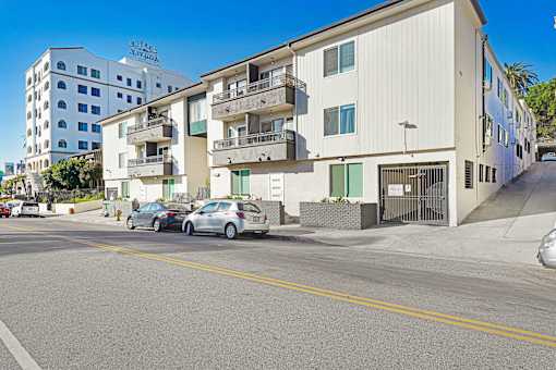 A street view of a residential area with cars parked on the side of the road.