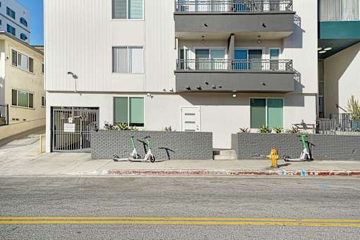 A white building with a yellow fire hydrant in front of it.