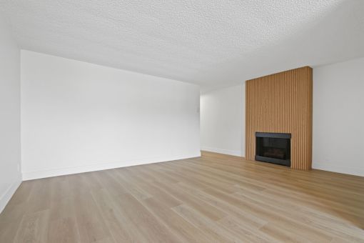 A room with a fireplace and wooden flooring.