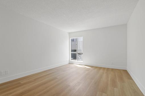 A room with wooden flooring and a window.