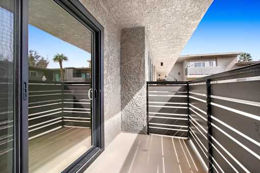 A balcony with a glass door and a concrete pillar.