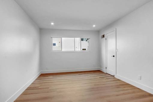 A room with a wooden floor and a white door.