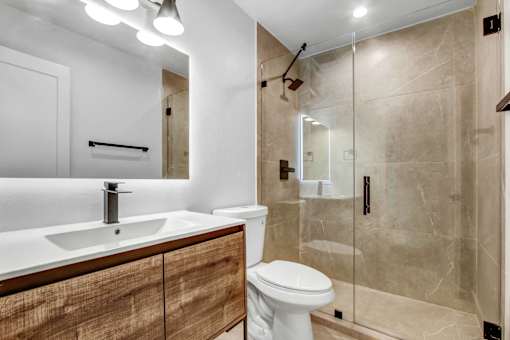 A modern bathroom with a white sink and toilet.