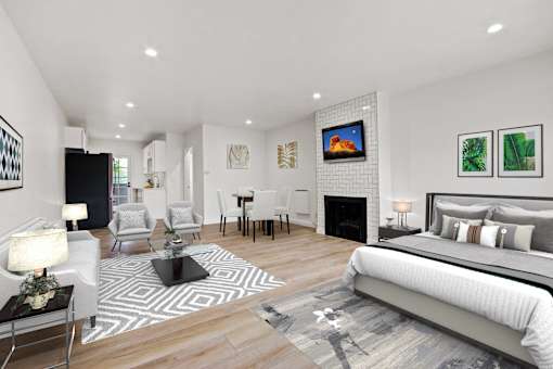 A modern bedroom with a large bed and a fireplace.