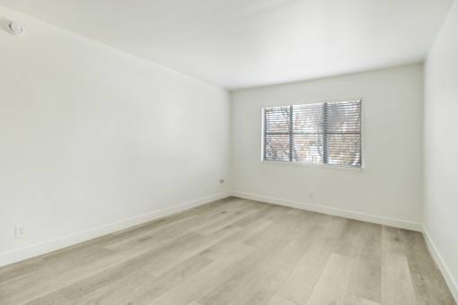 A room with a window covered by blinds.