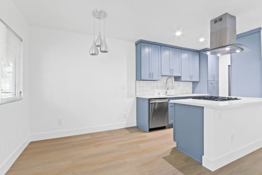 a kitchen with blue and white cabinets and a white counter top