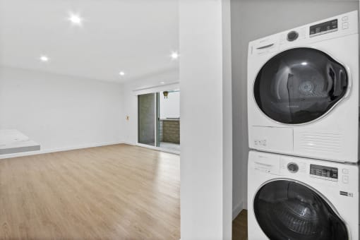 a washer and dryer in a room with a wood floor and a white