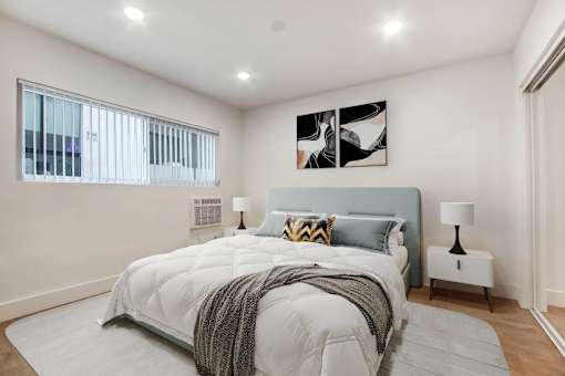A bedroom with a large bed and a window.