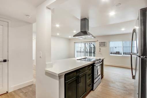 A modern kitchen with a black fridge and stove.