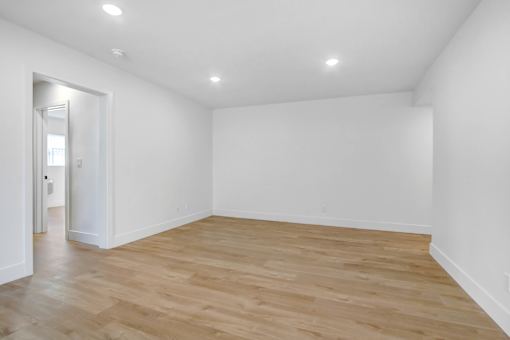 A room with wooden flooring and white walls.