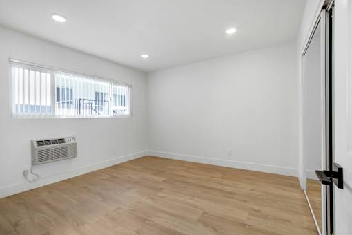 A room with a window and a wall-mounted air conditioner.