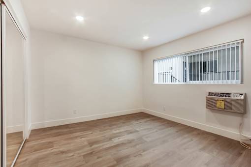 A room with a window and a wall-mounted heater.