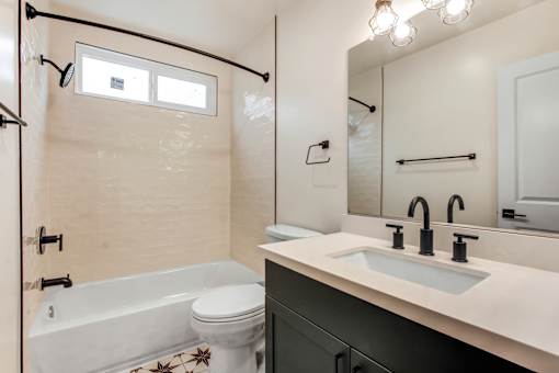 A white toilet with a star design on it is in a bathroom with a white tub and a sink.