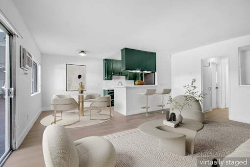 A modern living room with a white sofa and a green cabinet.