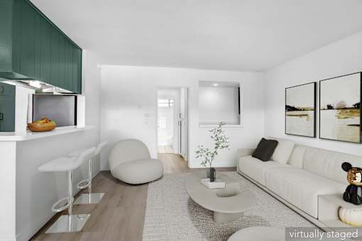 A modern living room with a white couch, a grey coffee table, and a white chair.