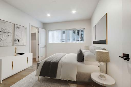 A bedroom with a bed, nightstand, and artwork on the wall.