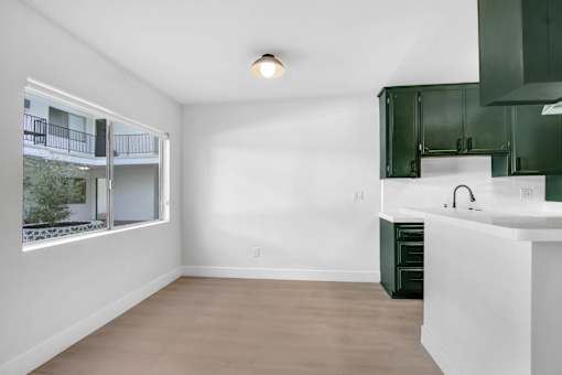 A kitchen with green cabinets and a white countertop.