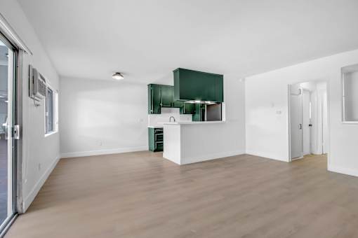 A room with a white wall and a green cabinet.