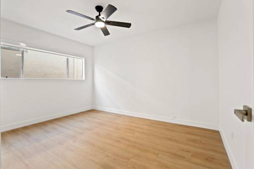 A room with a ceiling fan and a window.
