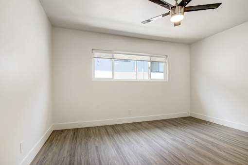 A room with a ceiling fan and a window.