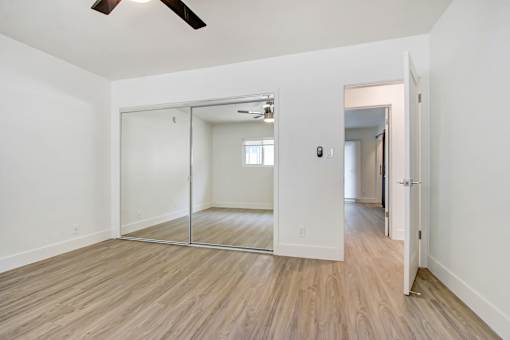 A room with a sliding door and a ceiling fan.