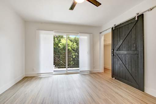 A room with a sliding door and a ceiling fan.