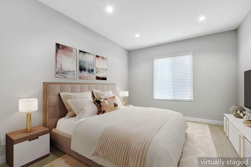 A bedroom with a large bed and a painting on the wall.