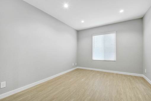 A room with a window and wooden flooring.