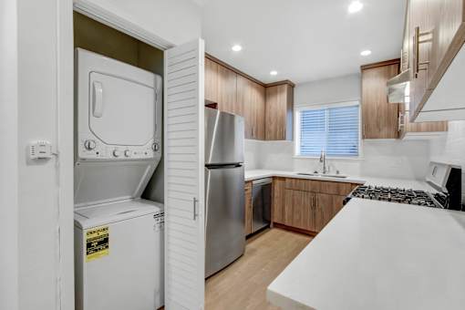A modern kitchen with a white countertop and stainless steel appliances.