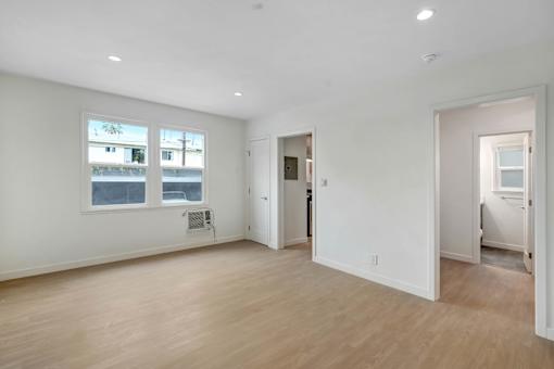 A large empty room with wooden floors and white walls.