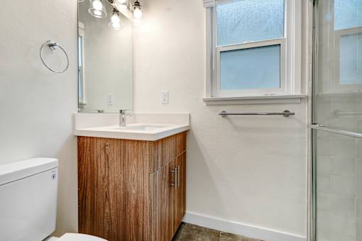 A bathroom with a toilet, sink, and shower.