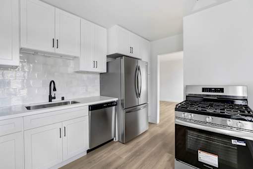 A modern kitchen with white cabinets and stainless steel appliances.