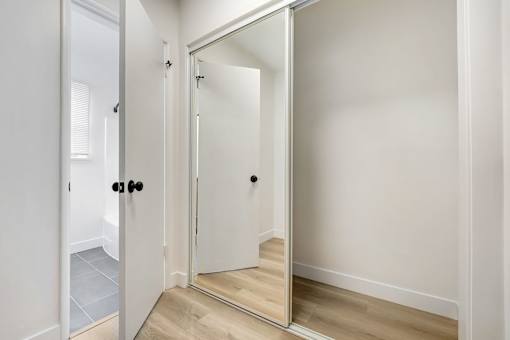 A white door with a mirror on the right side.