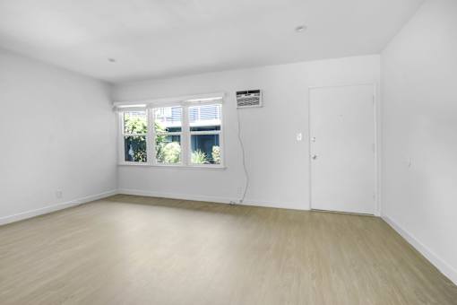 A room with a white door and a window with blinds.