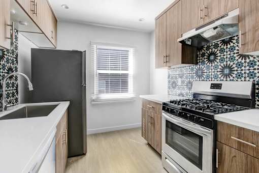 A kitchen with a black refrigerator, stove, and oven.
