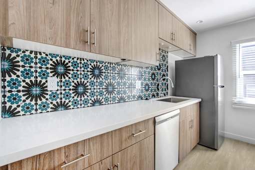 A kitchen with wooden cabinets and a tile backsplash.