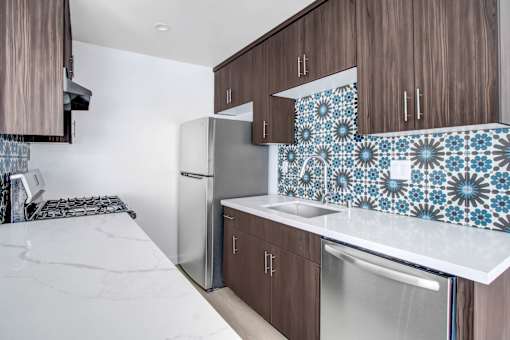 A kitchen with brown cabinets and a white counter top.